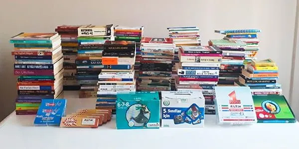 A large pile of books on a table.